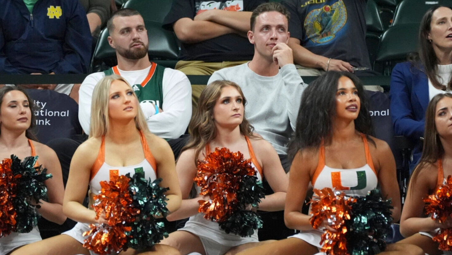 El quarterback de fútbol americano de Miami, Carson Beck, en el centro, observa la primera parte de un partido de baloncesto universitario de la NCAA entre Miami y Notre Dame, el jueves 20 de febrero de 2025, en Coral Gables, Florida. (Rebecca Blackwell/AP Photo).