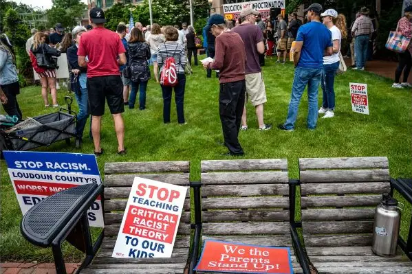 Carteles colocados en un banco durante una manifestación contra la "teoría crítica de la raza" que se enseña en las escuelas del centro gubernamental del condado de Loudoun en Leesburg, Virginia, el 12 de junio de 2021. (Andrew Caballero-Reynolds/AFP vía Getty Images)