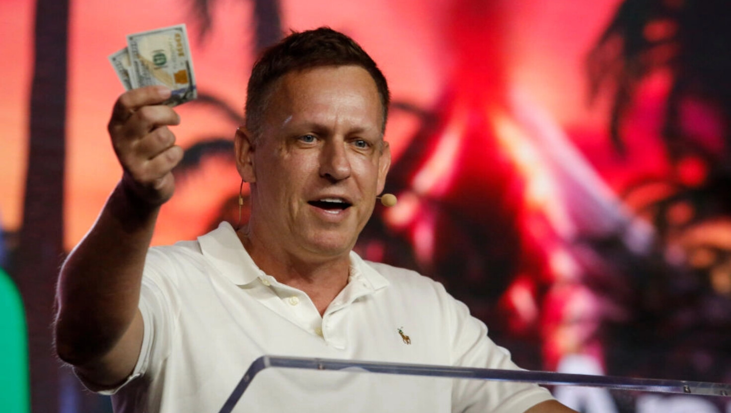 Peter Thiel, cofundador de PayPal, Palantir Technologies y Founders Fund, sostiene billetes de cien dólares mientras habla durante la Conferencia Bitcoin 2022 en el Centro de Convenciones de Miami Beach en Miami, Florida, el 7 de abril de 2022. (Marco Bello/Getty Images).