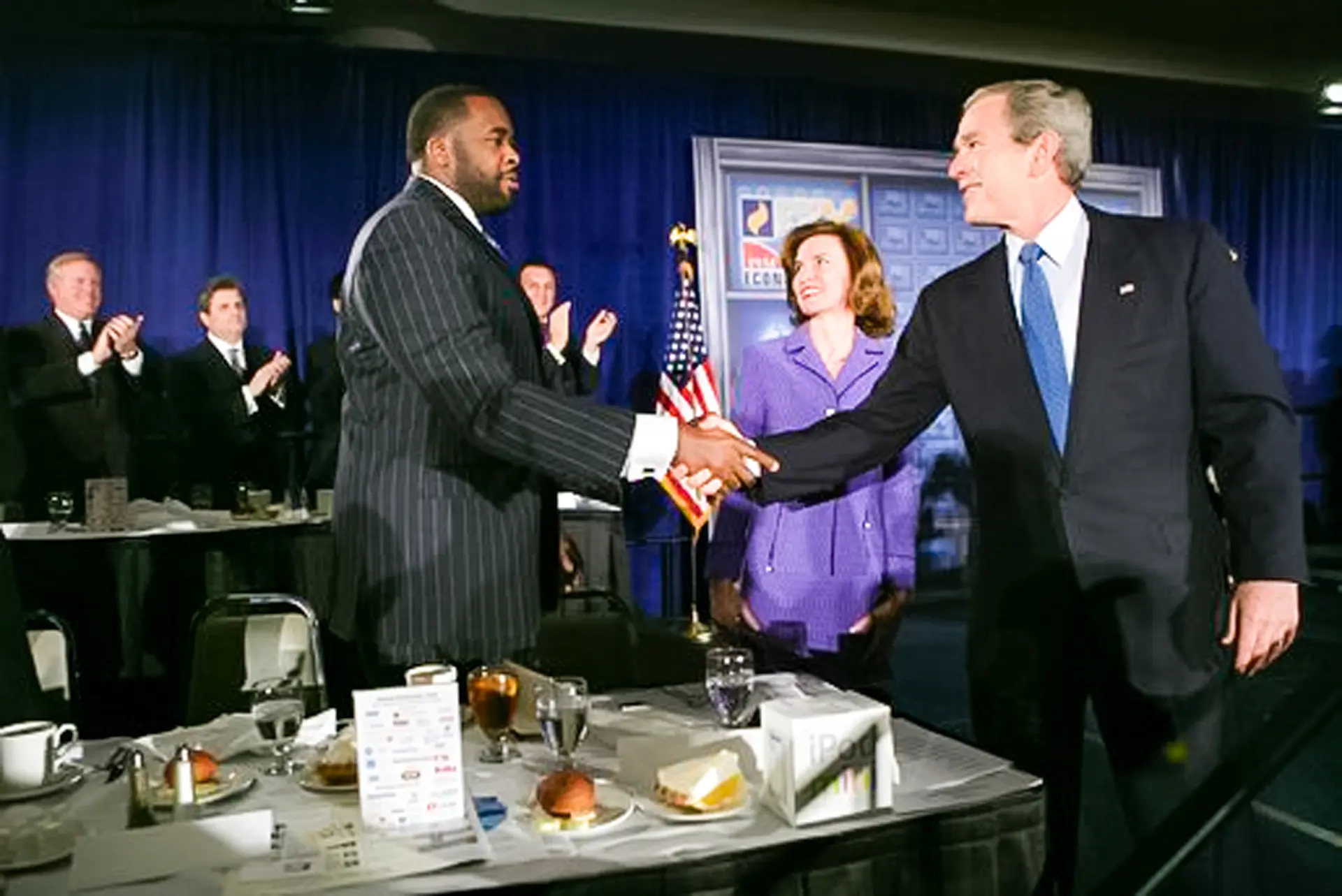 El alcalde de Detroit, Kwame Kilpatrick, saluda al presidente George W. Bush en 2005. En 2005, Kilpatrick fue reelegido para un segundo mandato como alcalde. (Dominio público)