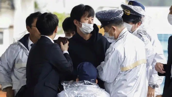 Ryuji Kimura (centro) cuando es capturado por la policía después de arrojar una bomba casera al exprimer ministro de Japón Fumio Kishida durante un evento de campaña en Wakayama, oeste de Japón, el 15 de abril de 2023. (Kyodo News vía AP)