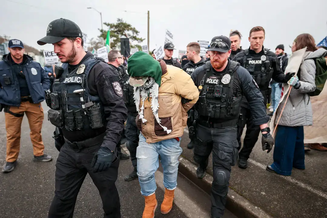 Agentes de policía de Seattle detienen a un manifestante durante una marcha contra el Servicio de Inmigración y Control de Aduanas en Seattle el 8 de febrero de 2025. (Jason Redmond/AFP a través de Getty Images)