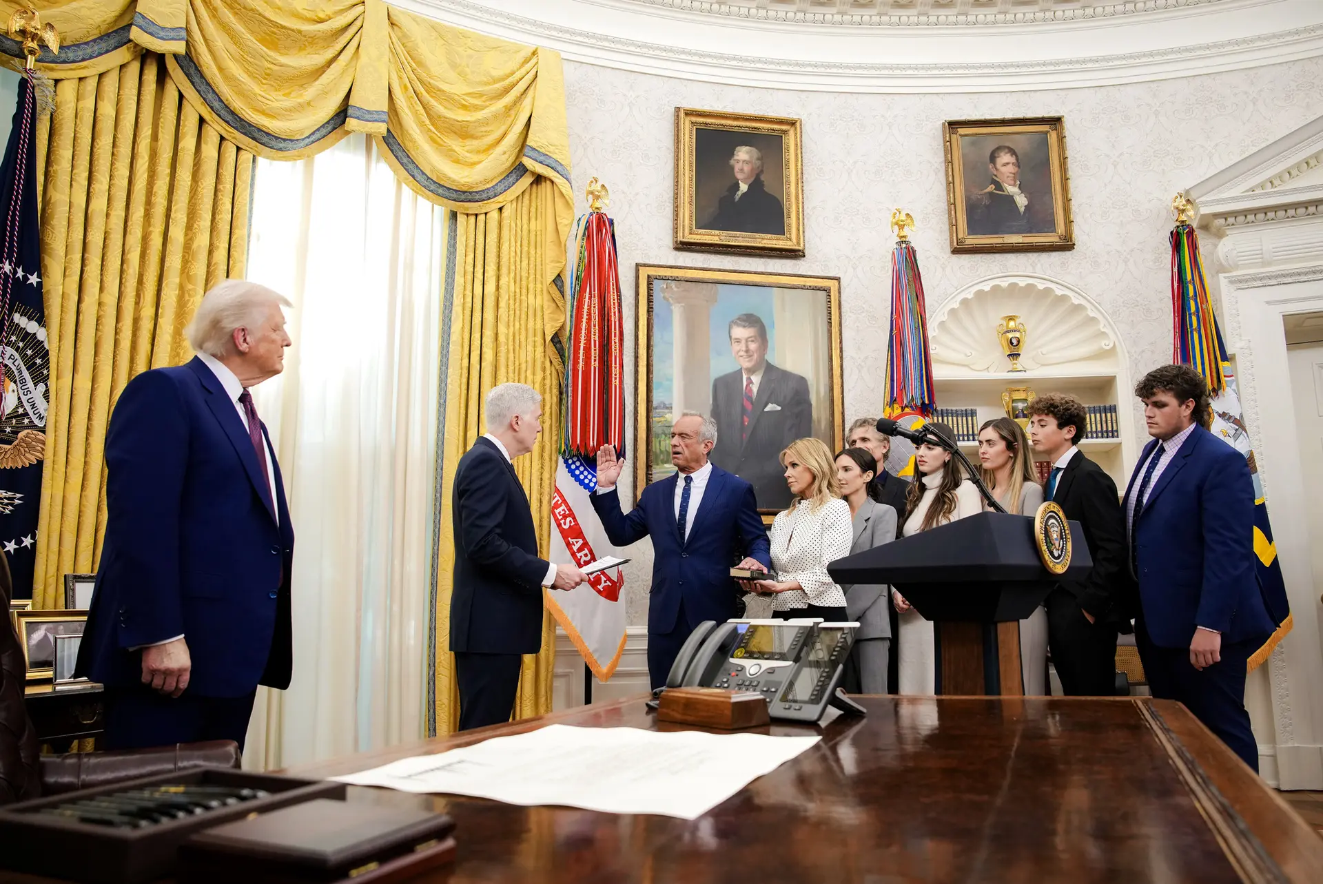 Robert F. Kennedy Jr., acompañado por su esposa, Cheryl Hines, y su familia, presta juramento como secretario de Salud y Servicios Humanos ante el juez de la Corte Suprema Neil Gorsuch, mientras el presidente Donald Trump observa, en la Oficina Oval el 13 de febrero de 2025. (Andrew Harnik/Getty Images)