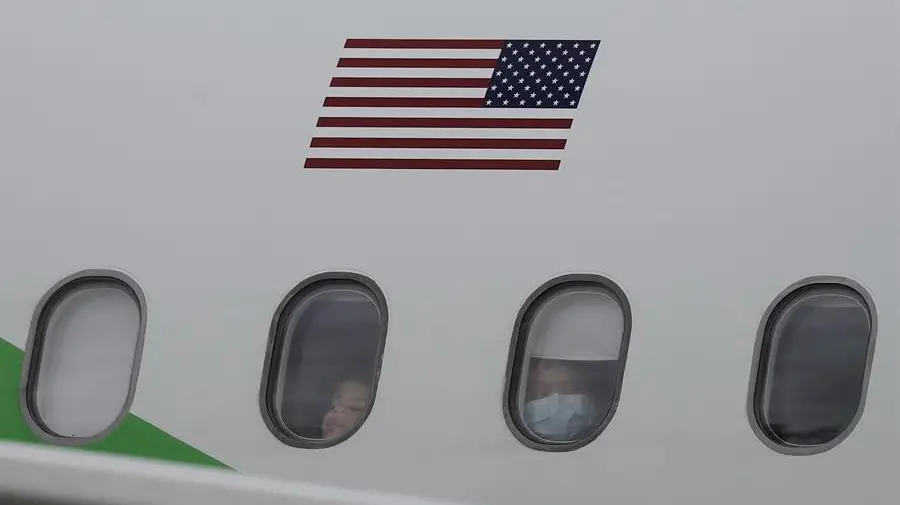 Migrantes provenientes de Estados Unidos observan por la ventana de un avión en el que fueron enviados de regreso a casa. EFE/ Jeffrey Arguedas