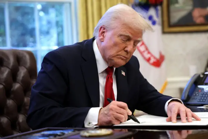 El presidente de Estados Unidos, Donald Trump, firma una orden ejecutiva anunciando aranceles a las importaciones de automóviles en el Despacho Oval de la Casa Blanca en Washington, el 26 de marzo de 2025. (Win McNamee/Getty Images)