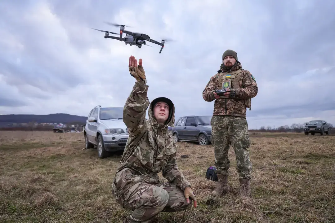 Participantes practican el vuelo de un dron, en este caso para localizar a compañeros que se escondían y simulaban ser francotiradores enemigos, durante una jornada de entrenamiento de combate organizada por una formación civil paramilitar local llamada TSEL, en la región de Lviv, Ucrania, el 22 de febrero de 2023. (Sean Gallup/Getty Images)