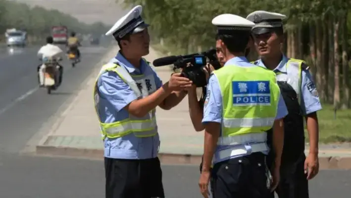 La policía china detiene a un periodista en un puesto de control en la carretera que conduce a la ciudad uigur de Lukqun, en la provincia de Xinjiang, afectada por disturbios, el 28 de junio de 2013. (Mark Ralston/AFP vía Getty Images)