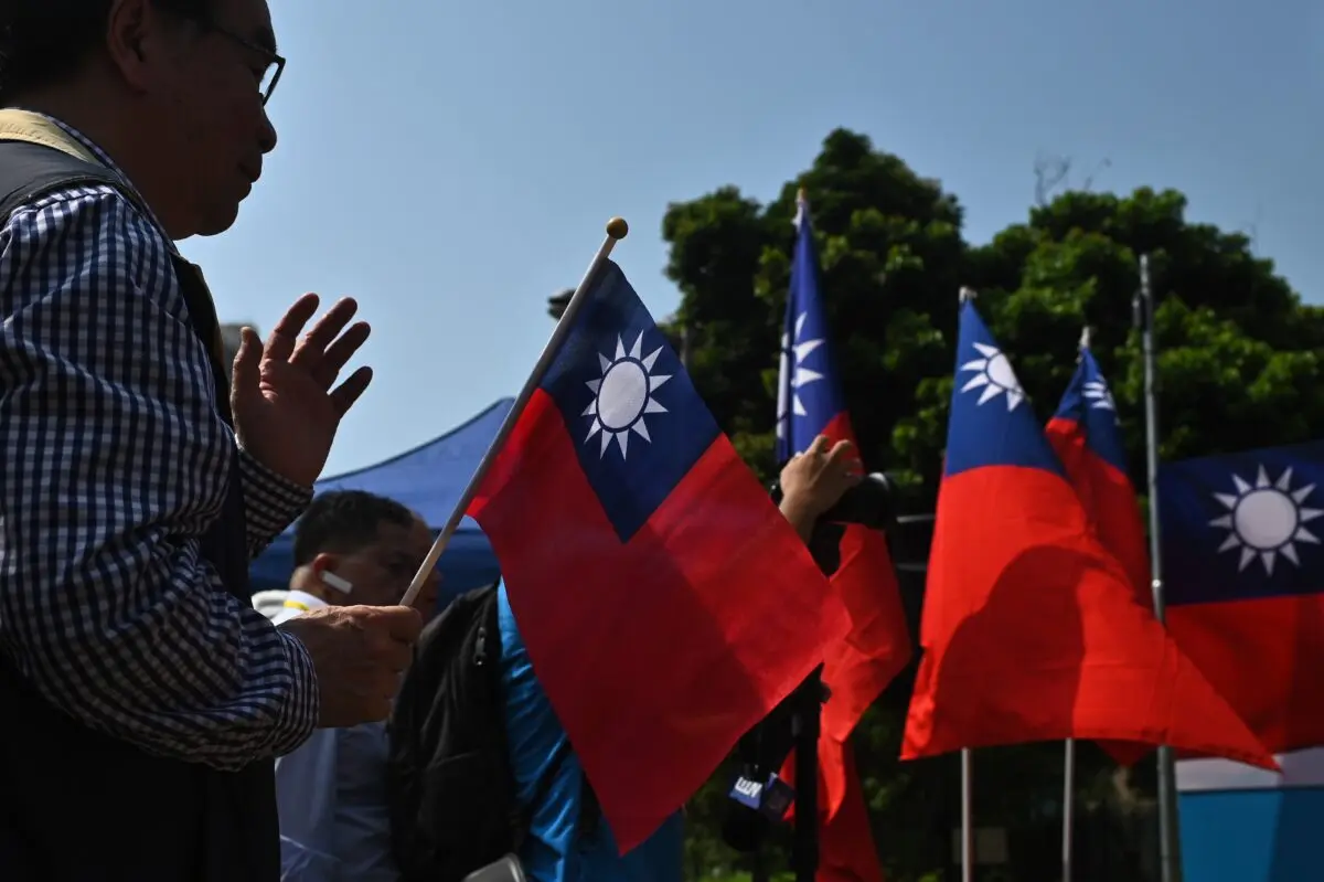 Un hombre sostiene una bandera taiwanesa durante una ceremonia de izado de bandera para conmemorar el 108.º aniversario de la fundación de la República de China, en el distrito de Tuen Mun, en Hong Kong, el 10 de octubre de 2019. (Philip Fong/AFP a través de Getty Images)