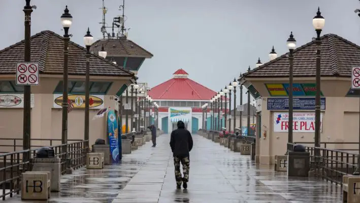 Un hombre camina bajo una tormenta en Huntington Beach, California, el 20 de febrero de 2024. (John Fredricks/The Epoch Times)