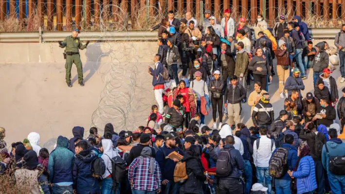 Un agente de la Patrulla Fronteriza de Estados Unidos habla con inmigrantes ilegales en El Paso, Texas, el 20 de diciembre de 2022. (John Moore/Getty Images)