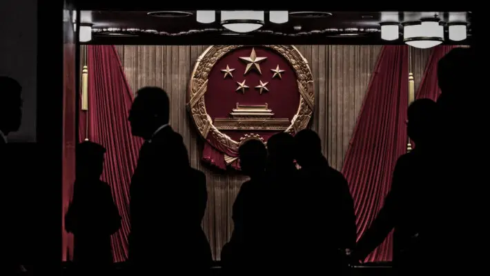 Delegados y guardias de seguridad se encuentran en la entrada del auditorio antes de la sesión de clausura del Congreso Nacional Popular en el Gran Salón del Pueblo en Beijing, el 11 de marzo de 2024. (Kevin Frayer/Getty Images)
