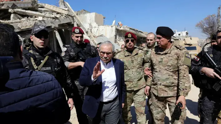 El primer ministro del Líbano, Nawaf Salam, camina entre soldados del ejército libanés mientras visita la aldea sureña de Khiam, cerca de la frontera con Israel, el 28 de febrero de 2025, tras la retirada el pasado diciembre de las fuerzas israelíes de la zona en virtud de un acuerdo de alto el fuego con Hezbolá. (Rabih Daher/AFP a través de Getty Images).