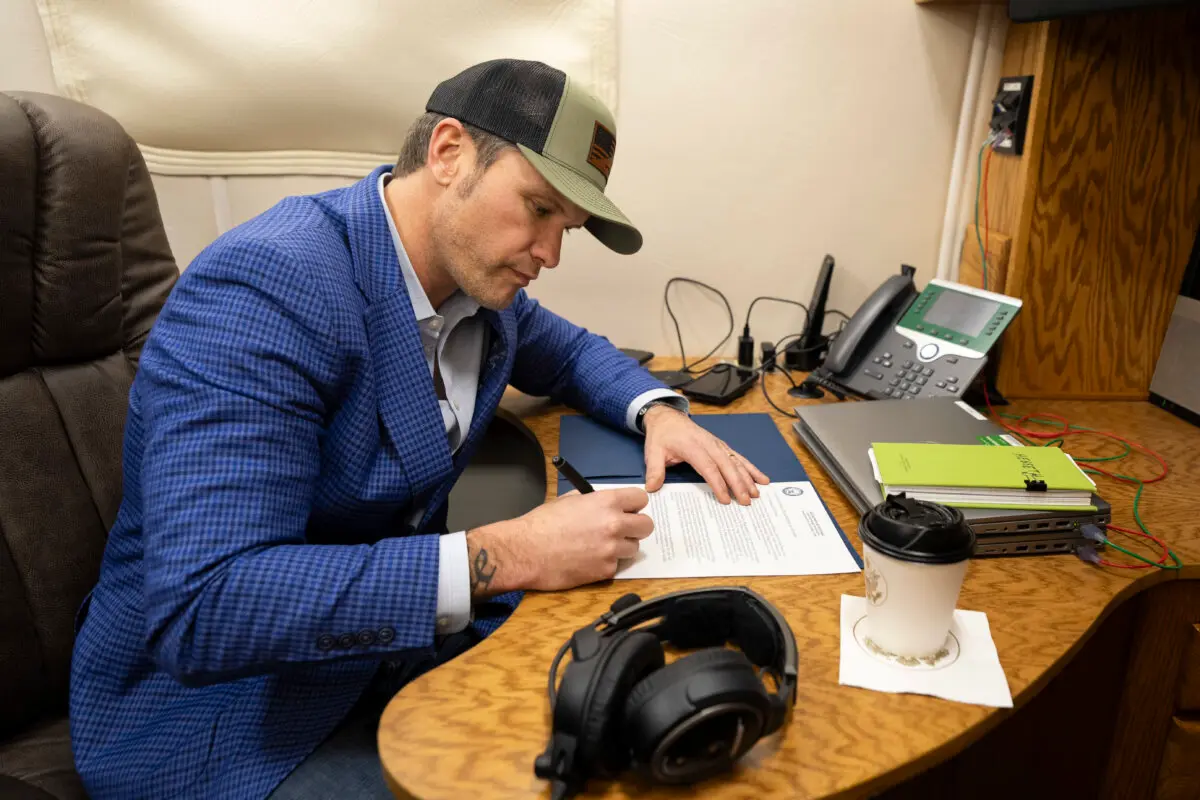 El secretario de Defensa Pete Hegseth firma un memorándum mientras vuela a Stuttgart, Alemania, el 10 de febrero de 2025. (Cortesía del suboficial de primera clase de la Marina de los EE. UU. Alexander Kubitza/DOD)