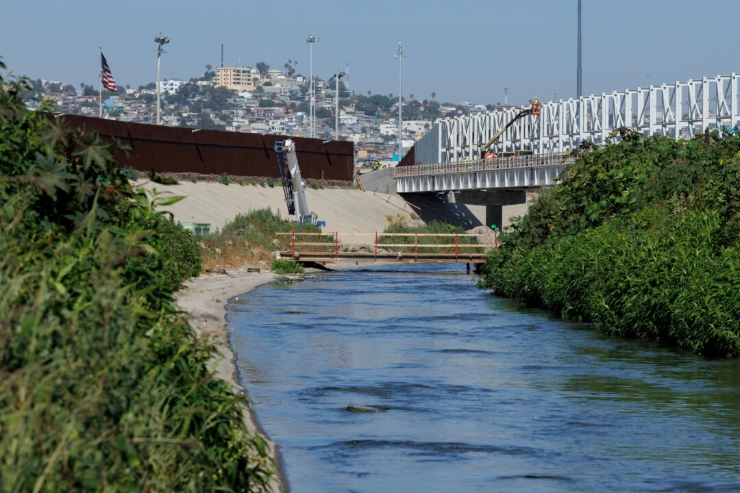 Las aguas residuales fluyen a lo largo del río Tijuana, situado entre las fronteras primaria y secundaria junto a Tijuana, México, en San Diego, el 27 de junio de 2024. (Mike Bake/Reuters)