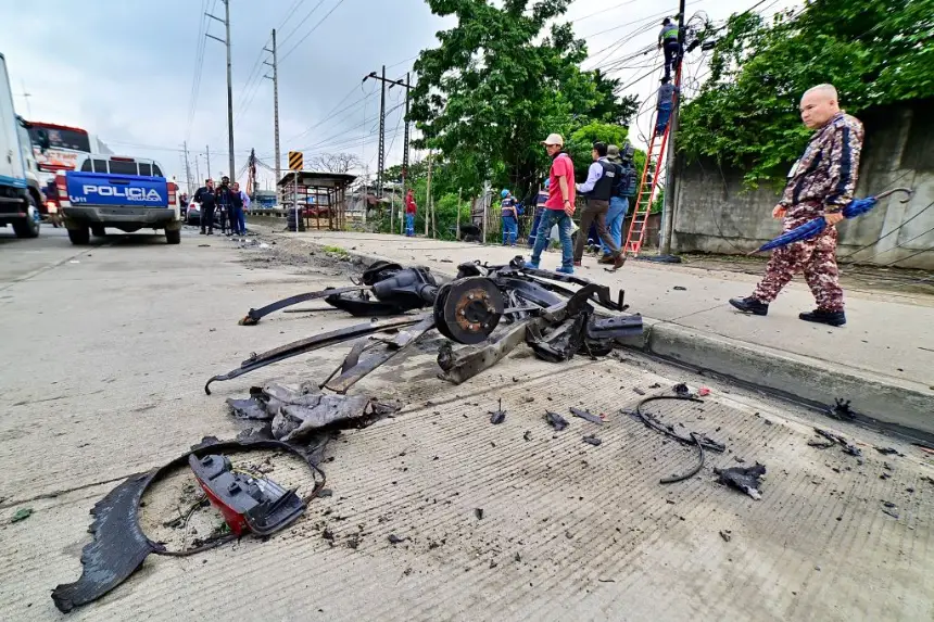 La gente camina junto a los escombros de un automóvil después de una explosión cerca de la prisión Litoral en Guayaquil, Ecuador, el 13 de marzo de 2025. (Marcos Pin/AFP vía Getty Images)