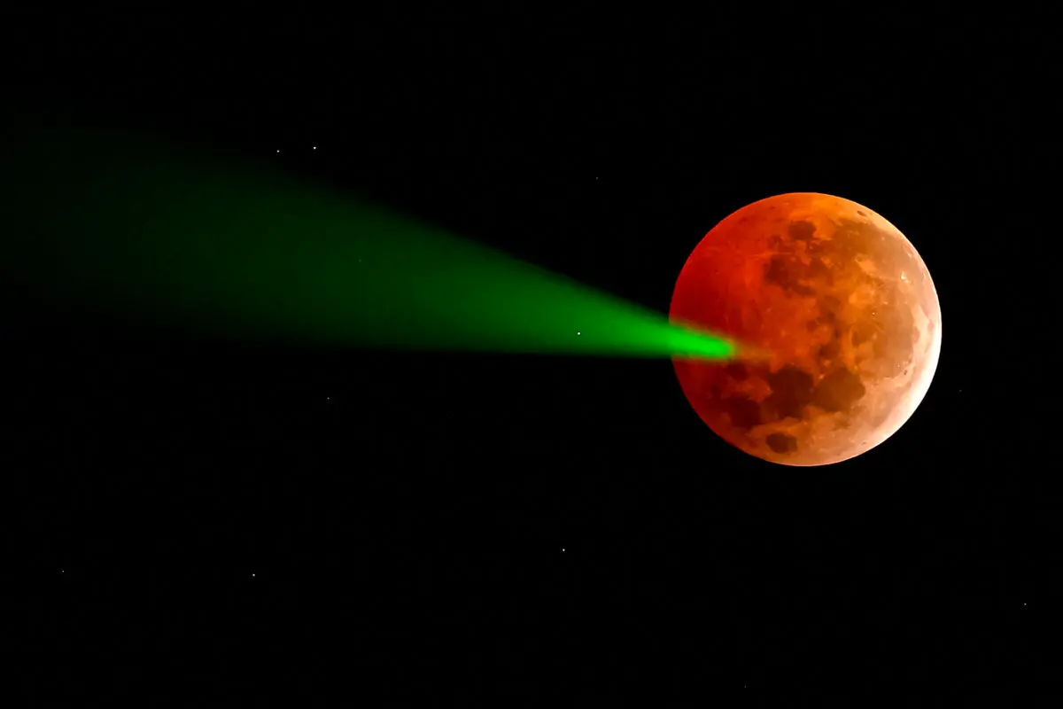 El eclipse de luna llena se apunta con un láser desde el telescopio del Observatorio Foster en Santiago de Chile, el 14 de marzo de 2025. (Javier Torres/AFP a través de Getty Images)