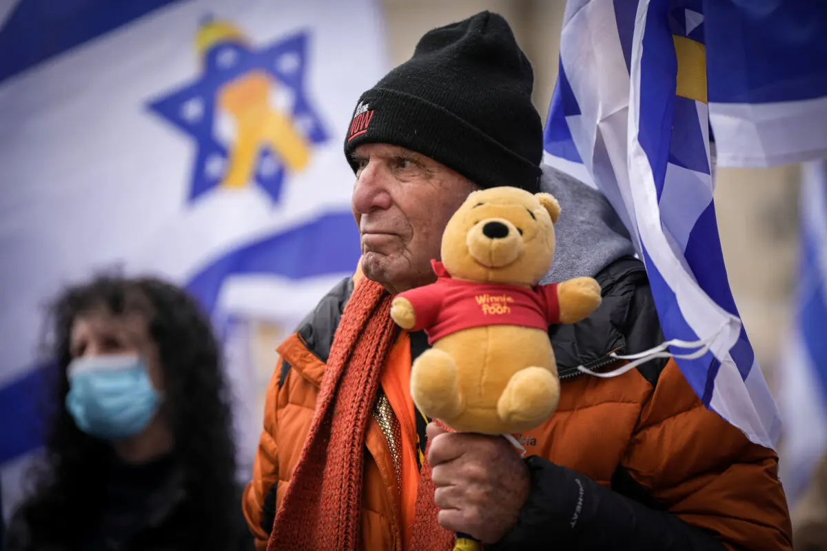 Un hombre sostiene un osito de peluche en la Plaza de los Rehenes de Tel Aviv, Israel, tras la entrega por Hamás de los cadáveres de cuatro rehenes, entre ellos dos niños, el 20 de febrero de 2025. (Oded Balilty/Foto AP)