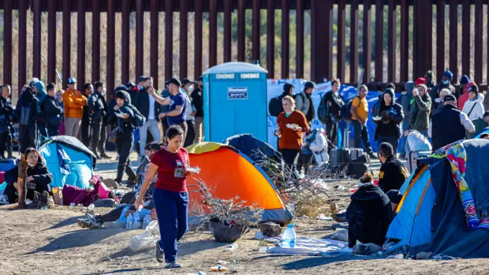 Inmigrantes ilegales que entraron en Estados Unidos a través de un hueco en el muro fronterizo esperan a que los agentes de la Patrulla Fronteriza los procesen en Jacumba, California, el 5 de diciembre de 2023. (John Fredricks/The Epoch Times).