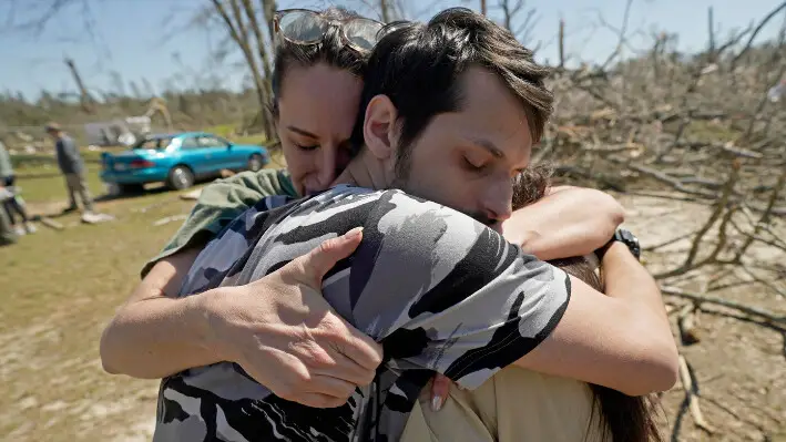 Steve Romero (centro) abraza a su esposa Hailey Hart (derecha) en Tylertown, Misisipi, el 16 de marzo de 2024. (Rogelio V. Solis/AP Photo).