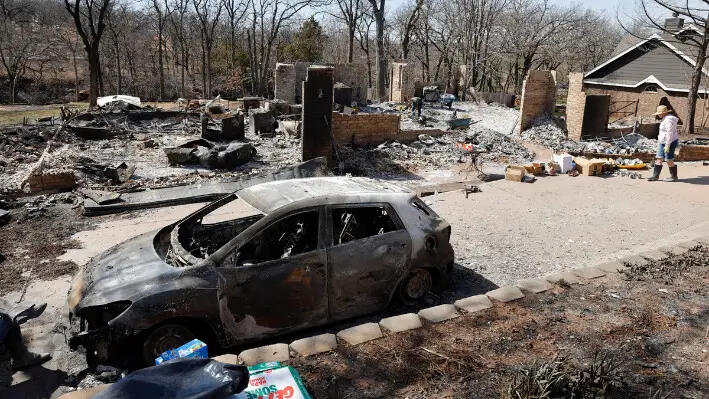 Andrine Shufran (D) mira las cenizas que quedan de su casa en el barrio de Hidden Oaks en Stillwater, Oklahoma, el 17 de marzo de 2025, después de que los incendios forestales arrasaran la zona el 14 de marzo. (Alonzo Adams/AP Photo).