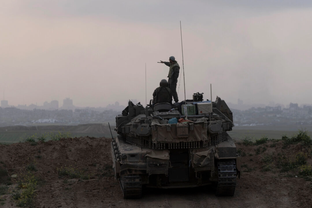 Soldados israelíes suben a un tanque mientras este toma posición frente al norte de la Franja de Gaza, visto desde el lado israelí de la frontera en el Distrito Sur de Israel, el 18 de marzo de 2025. (Amir Levy/Getty Images)