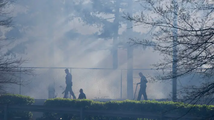 Bomberos trabajan para extinguir un incendio en una zona boscosa detrás de un Walmart en Little Rock, Arkansas, el 19 de marzo de 2025. (Adam Vogler/Arkansas Democrat-Gazette vía AP).