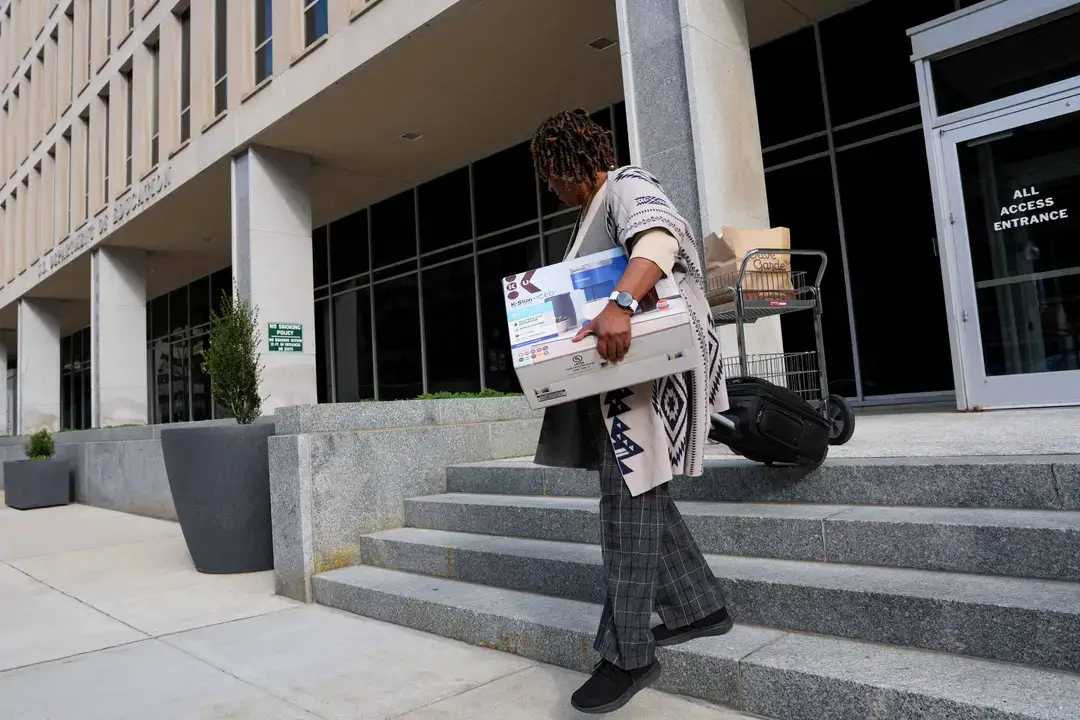 Un empleado del Departamento de Educación abandona el edificio con sus pertenencias en Washington, DC, el 20 de marzo de 2025. El presidente Donald Trump se prepara para firmar una orden ejecutiva para abolir el Departamento de Educación. (Win McNamee/Getty Images)