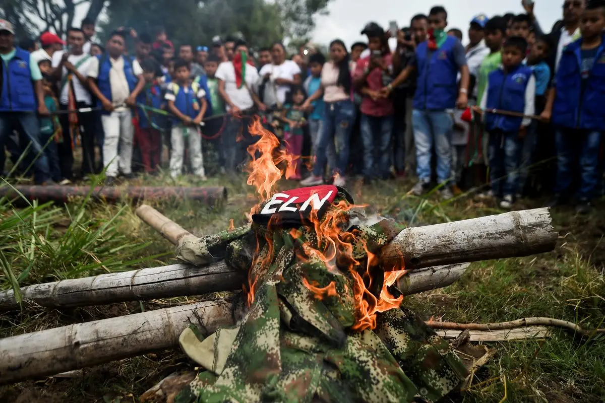 <em>Indígenas de la etnia Nasa queman uniformes incautados a guerrilleros del ELN en Corinto, departamento del Cauca, Colombia, el 6 de julio de 2018. Luis Robayo/AFP/Getty Images</em>