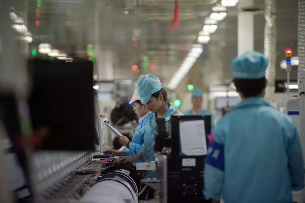 Trabajadores construyen circuitos para componentes de chips de teléfonos inteligentes en una fábrica de la ciudad de Dongguan, provincia de Guangdong, China, el 8 de mayo de 2017. (Nicolas Asforui/AFP/Getty Images)