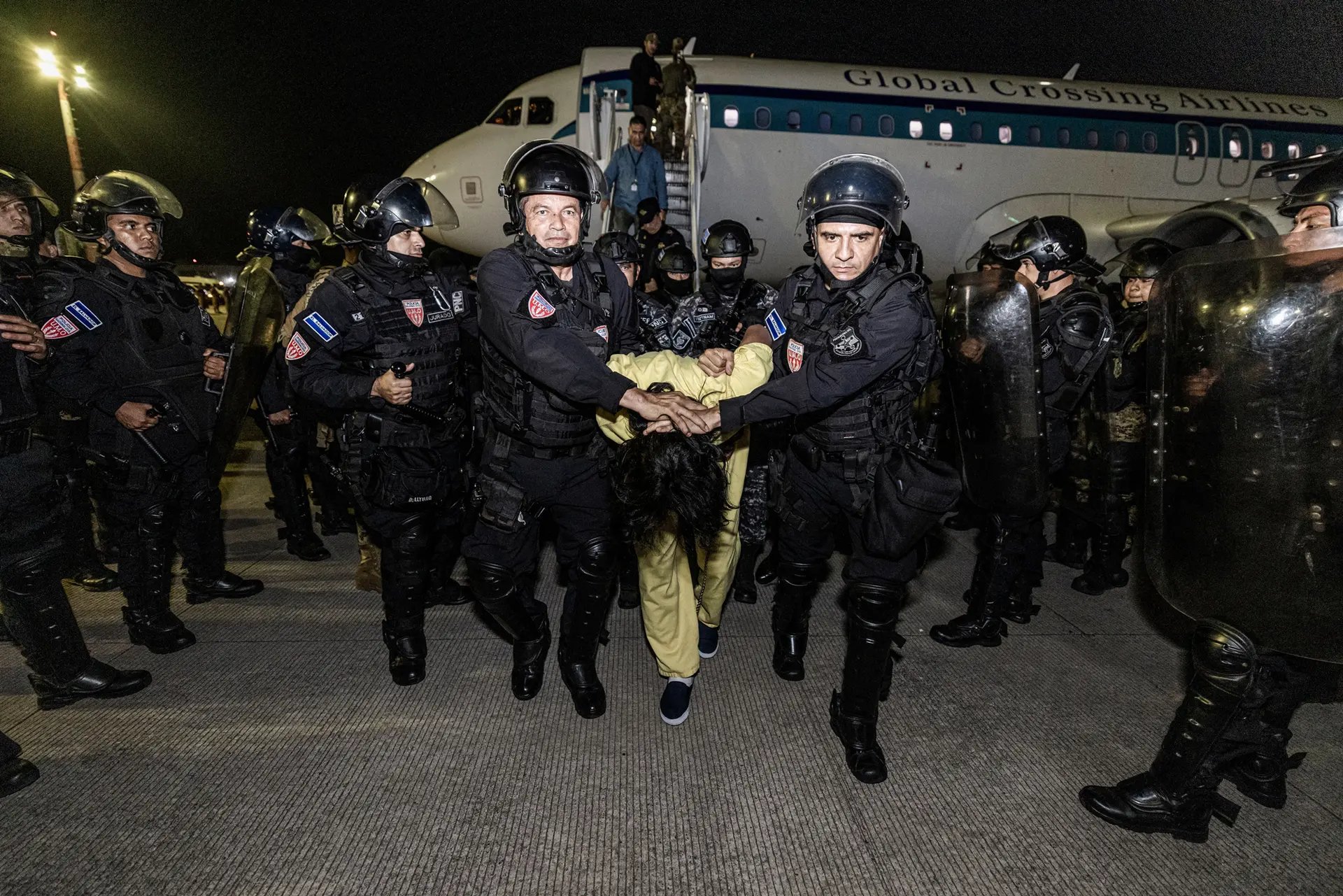 En esta foto proporcionada por el gobierno salvadoreño, los guardias escoltan a un recluso recién admitido al Centro de Confinamiento Terrorista (CECOT) en Tecoluca, El Salvador, el 16 de marzo de 2025. Estados Unidos deportó a 238 presuntos miembros de las bandas criminales venezolanas Tren De Aragua y Mara Salvatrucha. El presidente de El Salvador, Nayib Bukele, acordó detener a los pandilleros en nombre de Estados Unidos. (Gobierno salvadoreño vía Getty Images)