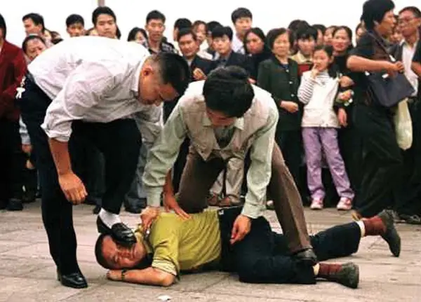 En esta foto sin fecha, se ve a oficiales de policía chinos vestidos de civil sosteniendo un cuchillo en un intento de “silenciar” a un practicante de Falun Dafa en China. (Crédito: Minghui.org)