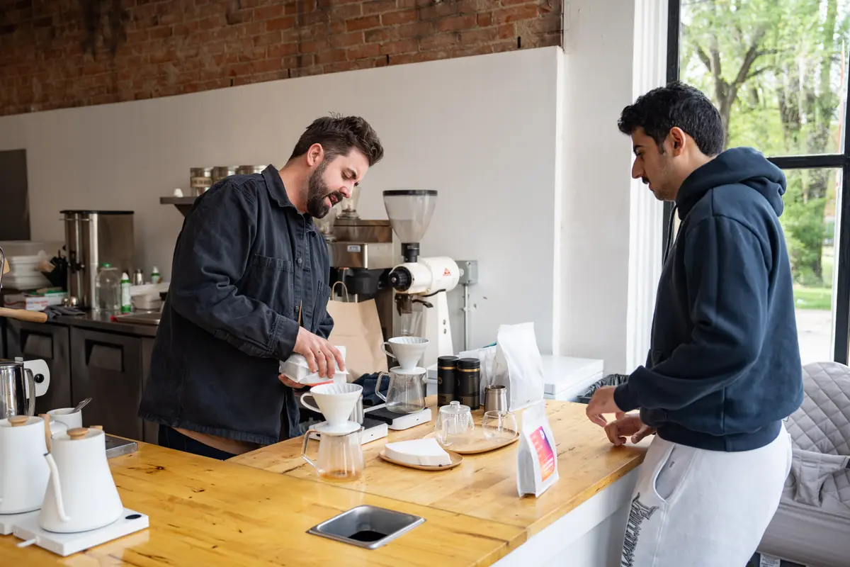 El candidato a la alcaldía de Cincinnati, Cory Bowman, atiende a un cliente en su cafetería en Cincinnati el 25 de abril de 2025. (Samira Bouaou/The Epoch Times)
