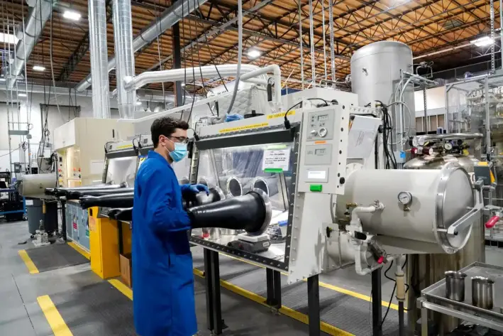 El ingeniero de pruebas Jacob Wilcox saca el brazo de una caja de guantes utilizada para procesar sodio en TerraPower, una empresa que desarrolla y construye pequeños reactores nucleares en Everett, Washington, el 13 de enero de 2022. (Elaine Thompson/AP Photo)