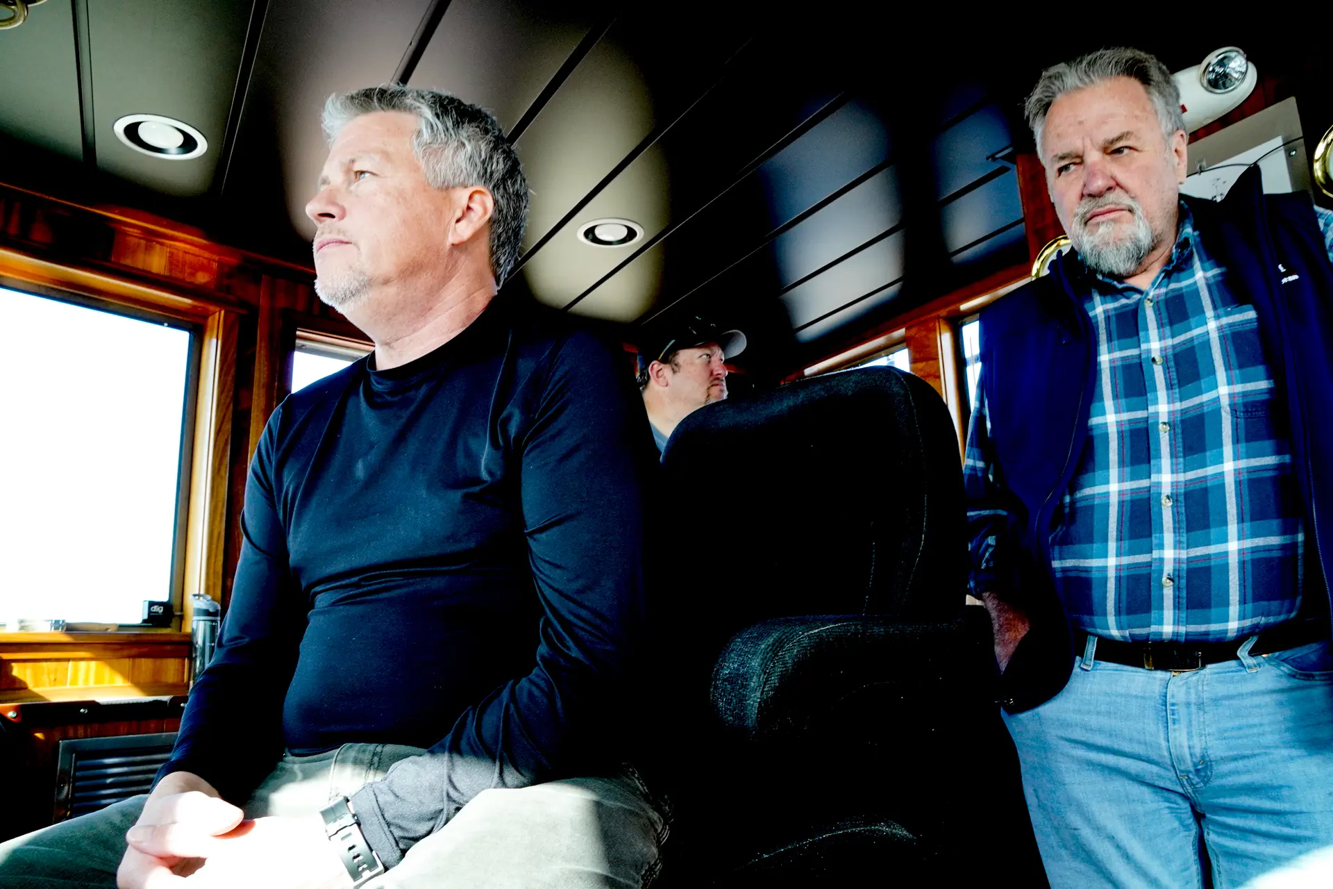 Sean O'Connell (izquierda), capitán del remolcador comercial Fishing Creek, sentado en la cabina de mando, mientras Igor Loch, director de operaciones marítimas de la costa oeste de Vane Brothers Co., observa. (Allan Stein/The Epoch Times)