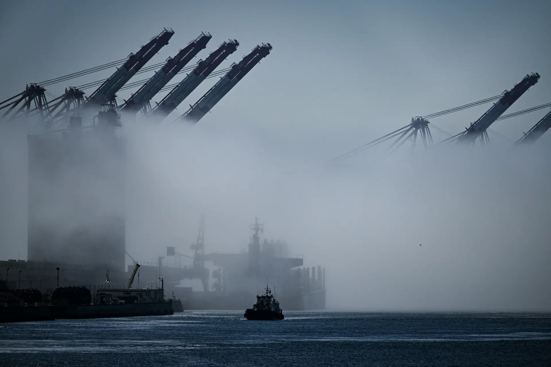 Un remolcador navega entre la niebla junto a grúas de carga en el puerto de Los Ángeles, en San Pedro (California), el 10 de abril de 2025. "Un conductor puede salir y huir del peligro", dijo Rosenberg, "pero los marineros no tienen la opción de detenerse y salir". (Patrick T. Fallon/AFP a través de Getty Images)