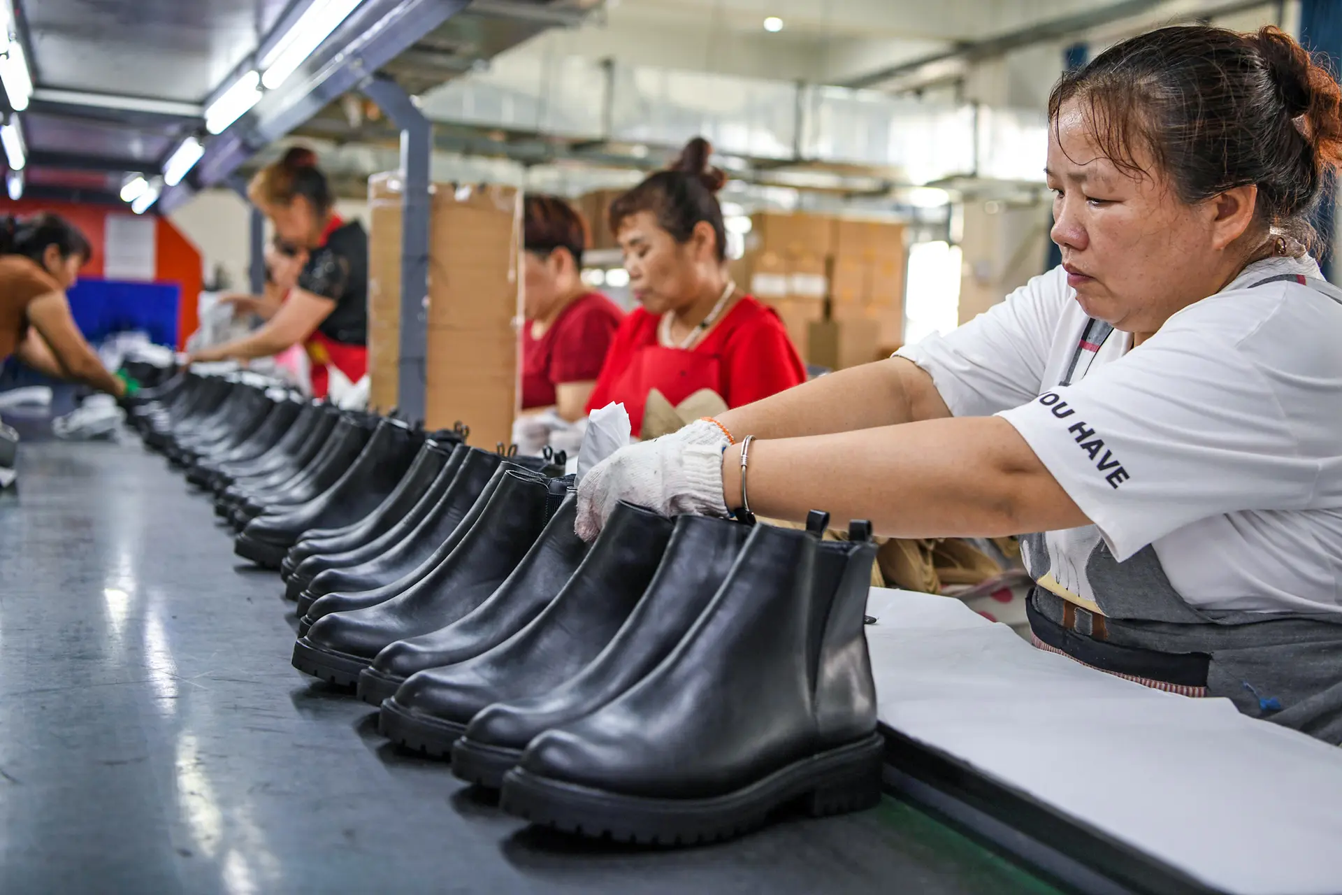 Trabajadores preparan zapatos para la exportación en una fábrica de Huainan, provincia de Anhui, China, el 6 de agosto de 2020. Para muchos exportadores chinos, competir internamente parece ser la única forma viable de seguir produciendo. (STR/AFP vía Getty Images)