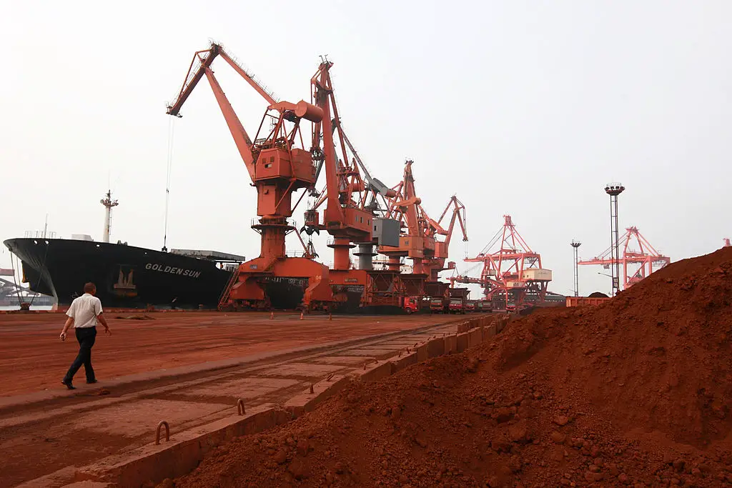 Una excavadora recoge tierra que contiene diversos metales raros para cargarla en un barco en un puerto de Lianyungang, en la provincia de Jiangsu, al este de China, el 5 de septiembre de 2010, para su exportación a Japón. (STR/AFP a través de Getty Images)