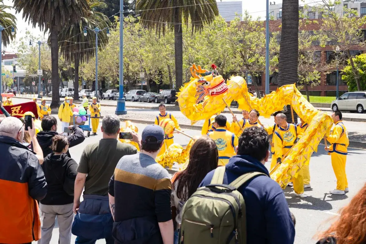 Los transeúntes observan una danza del dragón en un desfile que celebra el Día Mundial de Falun Dafa en San Francisco el 3 de mayo de 2025. (Gary Wang/The Epoch Times)
