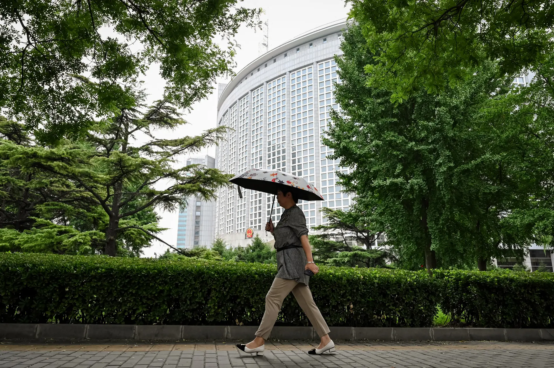 Una mujer pasa frente al Ministerio de Relaciones Exteriores en Beijing el 26 de julio de 2023. La mayoría de los productos chinos importados a Estados Unidos ahora enfrentan un arancel del 145 por ciento, incluido un impuesto del 20 por ciento que apunta al fentanilo. (Greg Baker/AFP vía Getty Images).