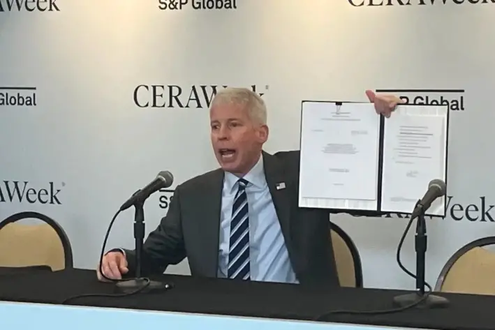 El secretario de Energía de Estados Unidos, Chris Wright, muestra la orden que firmó en marzo en la CERAWeek de S&P Global en Houston, en la que se aprueba el permiso de Delfin LNG para comenzar a exportar GNL desde su terminal offshore de Luisiana en 2029. (John Haughey/The Epoch Times)