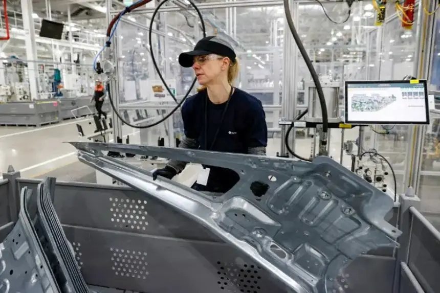 Una empleada trabaja en una cadena de montaje en la fábrica de vehículos eléctricos de la startup Rivian Automotive en Normal, Illinois, el 11 de abril de 2022. (Kamil Krzaczynski/Reuters)