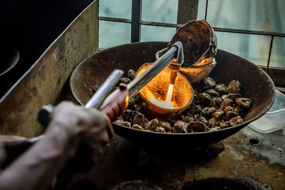 Un hombre funde fragmentos de oro puro procedentes de diferentes minas de la región, en un mercado de oro en Geita, Tanzania, el 28 de mayo de 2022. (Luis Tato/AFP a través de Getty Images)
