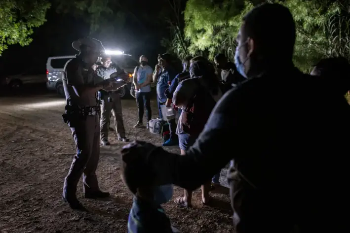 Inmigrantes ilegales de Venezuela se entregan a la policía estatal de Texas tras cruzar la frontera desde México hacia Del Río, Texas, el 18 de mayo de 2021. (John Moore/Getty Images)
