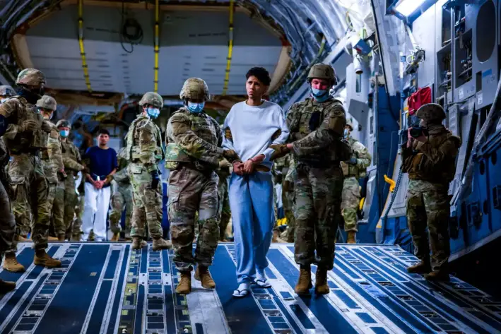 Personal militar estadounidense escolta a presuntos miembros de la banda venezolana Tren de Aragua y de la banda MS-13 recientemente deportados por el gobierno de Estados Unidos para ser encarcelados en el Centro de Confinamiento por Terrorismo (CECOT), en el marco de un acuerdo con el gobierno salvadoreño, en San Luis Talpa, El Salvador, el 30 de marzo de 2025. (Oficina del Secretario de Prensa del Presidente/Reuters)