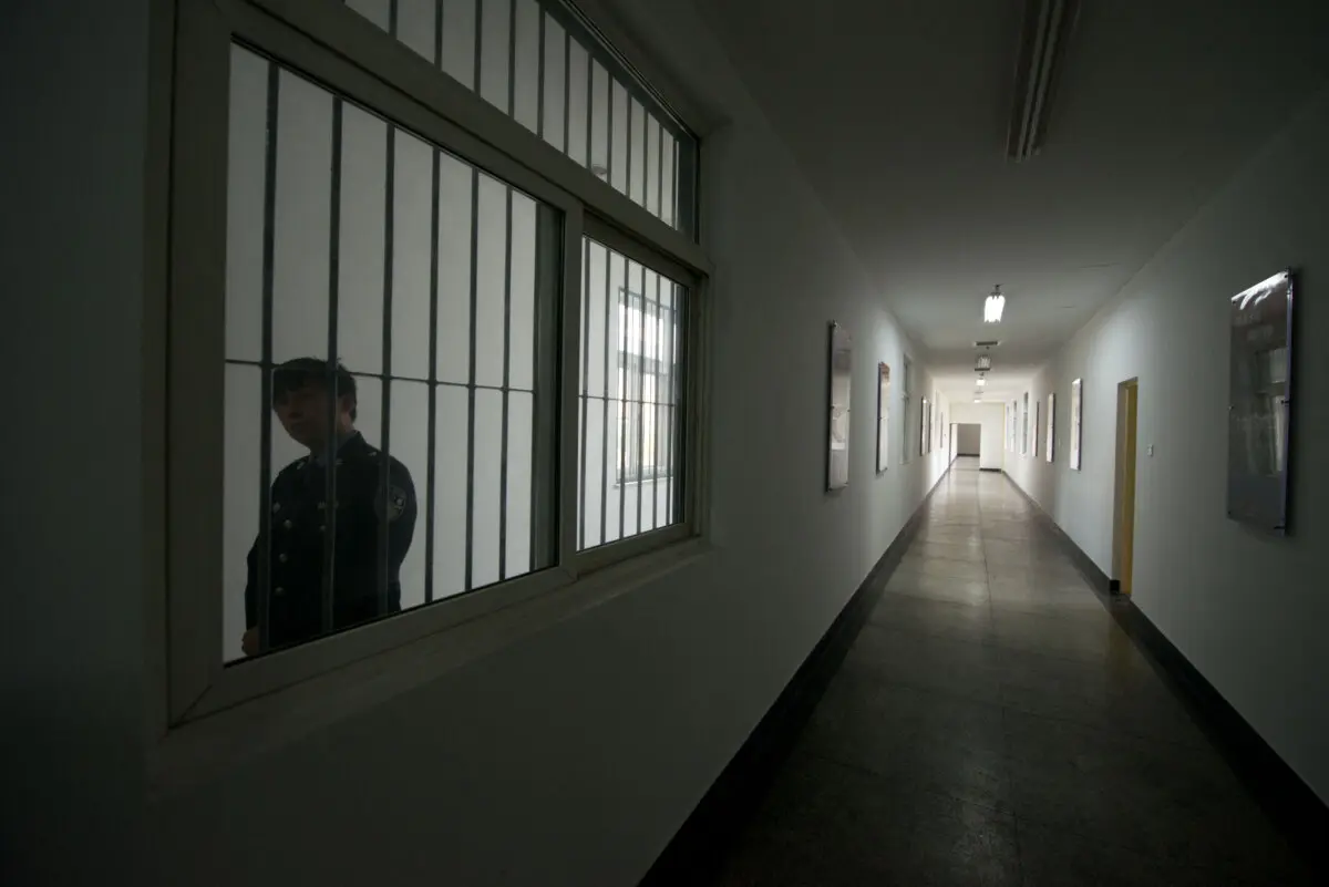 Un guardia mira a través de la ventana de un pasillo dentro de un centro de detención en Beijing, China, el 25 de octubre de 2012. (Ed Jones/AFP vía Getty Images).