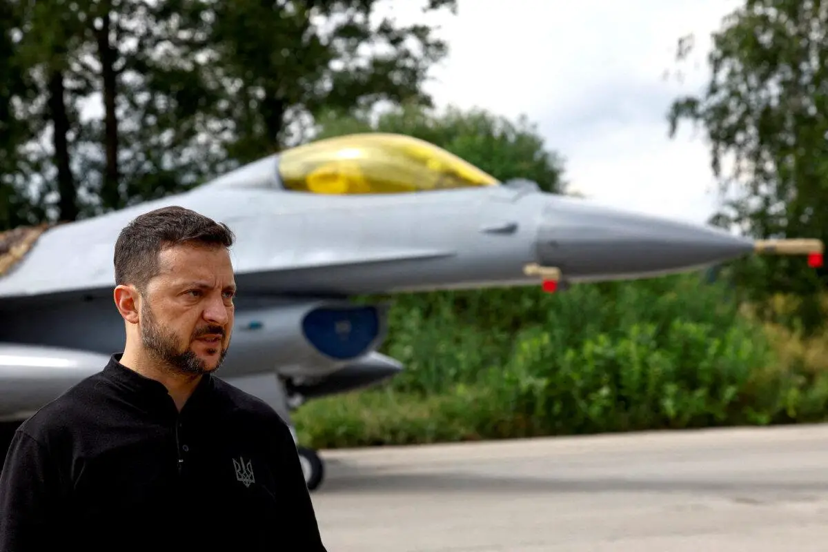 El presidente ucraniano, Volodímir Zelenski, junto a un caza F-16 en un lugar no revelado de Ucrania, el 4 de agosto de 2024. (Valentyn Ogirenko/Reuters)
