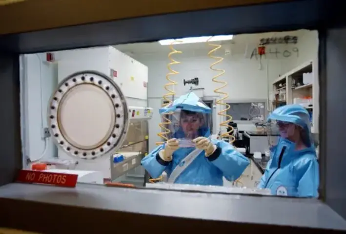 Personal trabajando en el laboratorio de bioseguridad de nivel 4 del Instituto de Investigación Médica de Enfermedades Infecciosas del Ejército de Estados Unidos en Fort Detrick, Maryland, el 26 de septiembre de 2002. (Olivier Douliery/AFP a través de Getty Images)