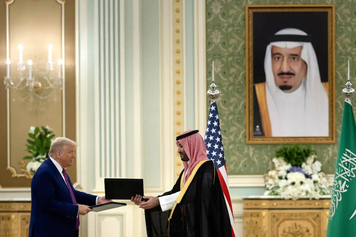 El presidente de EE. UU., Donald Trump, y el príncipe heredero de Arabia Saudí, Mohammed bin Salman, intercambian carpetas tras firmar un acuerdo durante una reunión bilateral en Riad el 13 de mayo de 2025. (Brendan Smialowski/AFP a través de Getty Images)