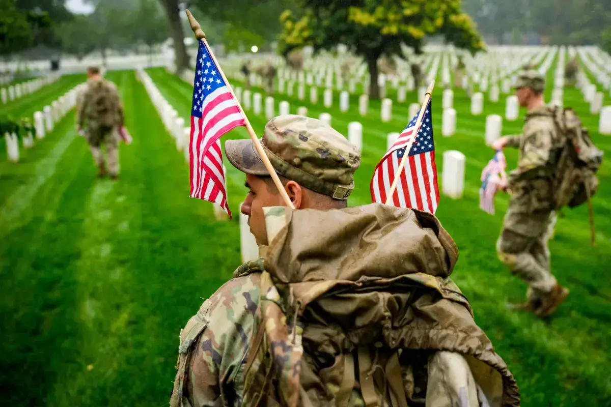 Miembros del 3.º Regimiento de Infantería de los Estados Unidos colocan banderas en las lápidas de militares estadounidenses enterrados en el Cementerio Nacional de Arlington, en preparación para el Día de los Caídos en Arlington, Virginia, el 22 de mayo de 2025. (Andrew Harnik/Getty Images)