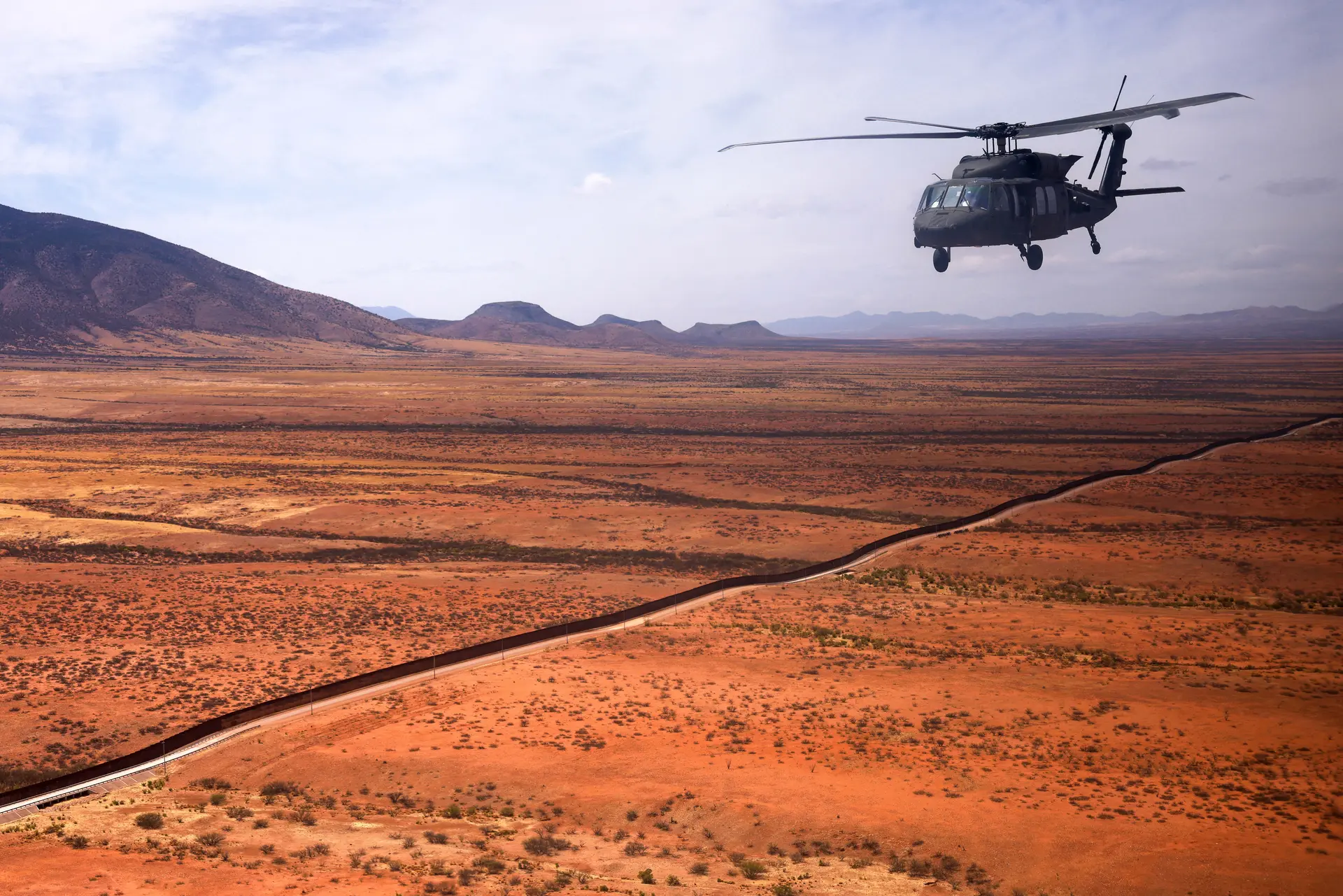 Una tripulación de Blackhawk vuela junto a la valla en la frontera sur de Estados Unidos con México, en Douglas, Arizona, el 3 de abril de 2025. (David Swanson/AFP vía Getty Images).